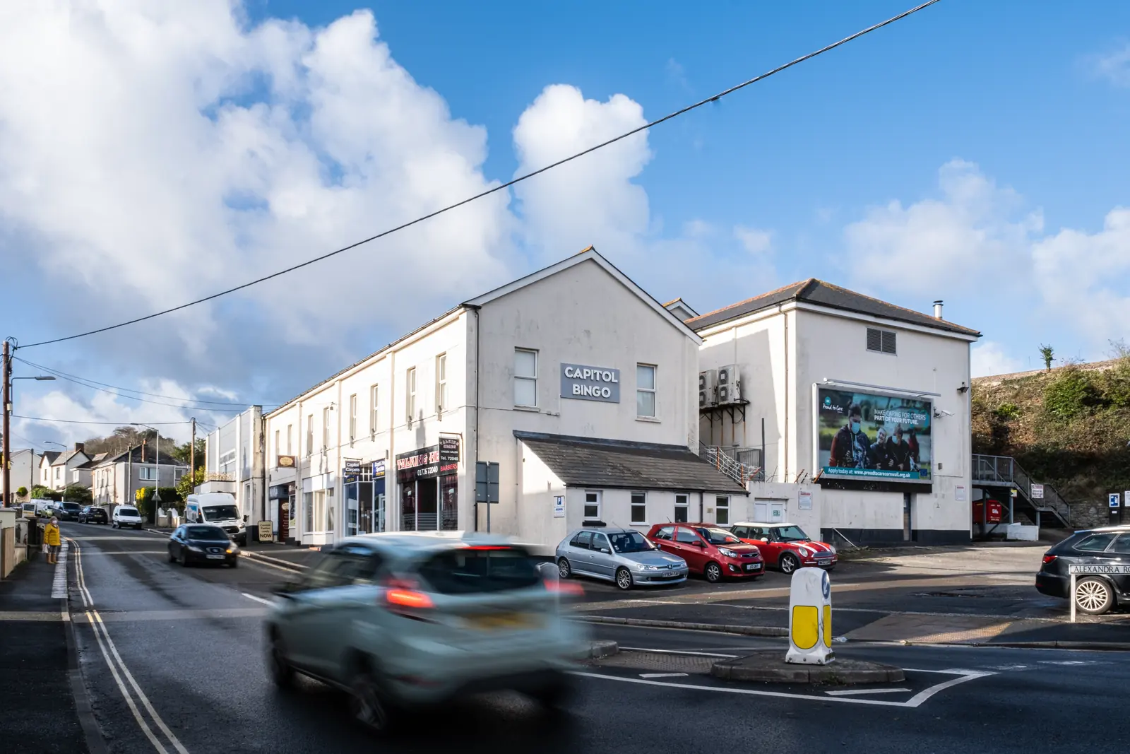 Alexandra Road billboard on the side of a building at the St Austell junction, traffic passing
