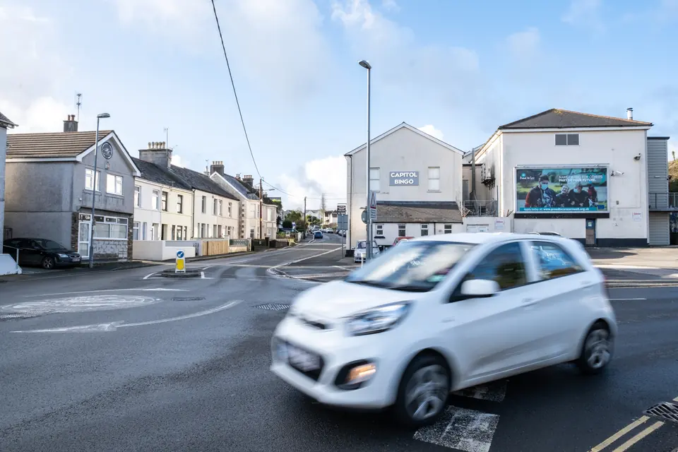 A car at the Alexandra Road junction in St Austell with the billboard in the background